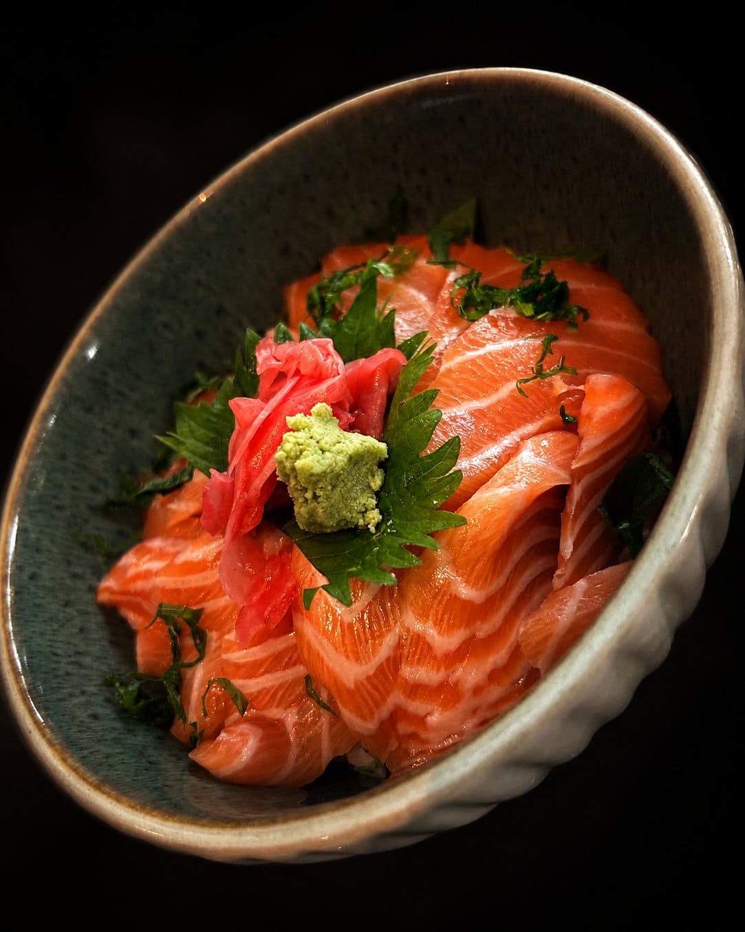 Shake don: fanned slices of salmon sashimi on rice with wasabi, pickled ginger and shiso leaf