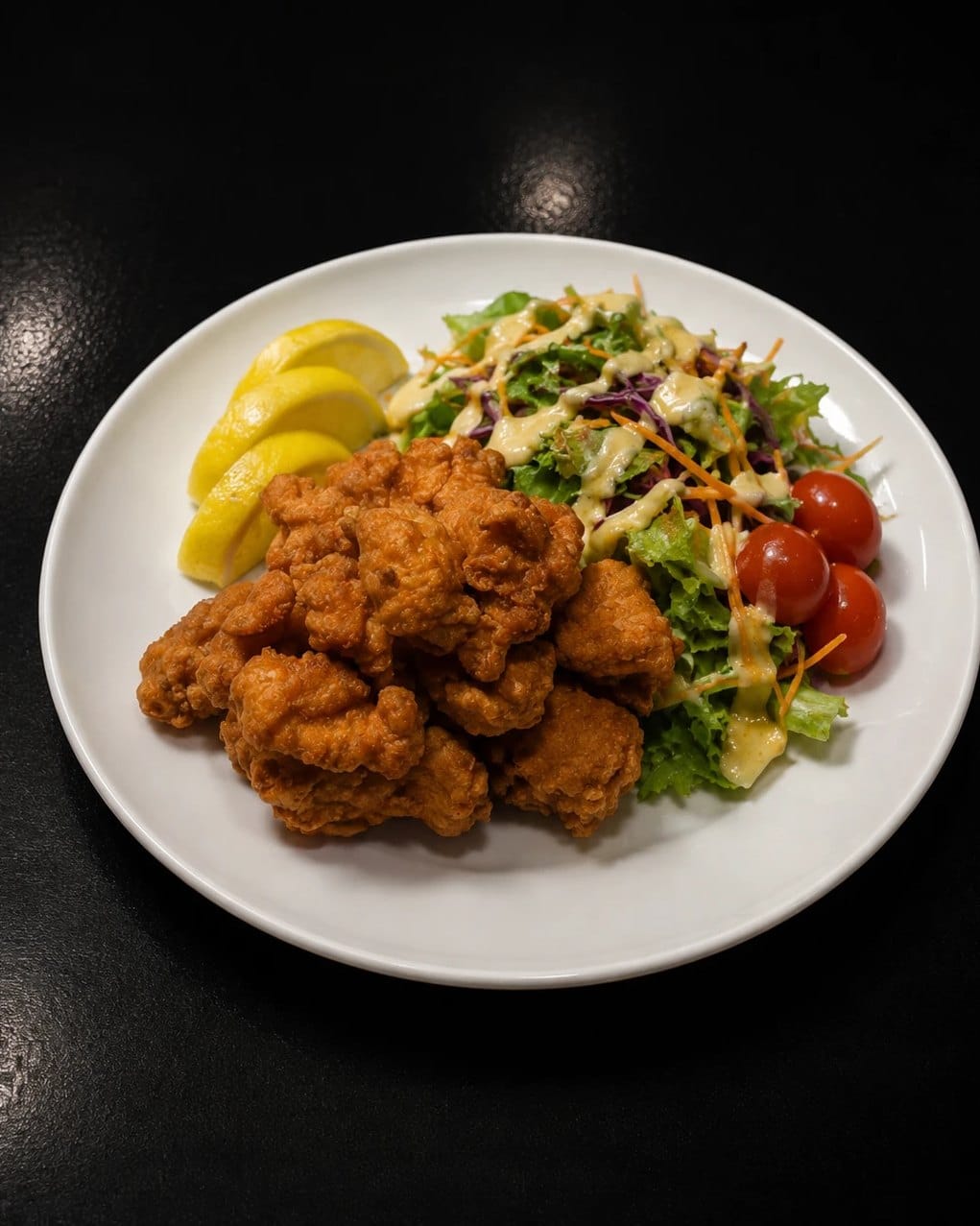 Tori karaage: Japanese fried chicken with salad, cherry tomatoes and lemon