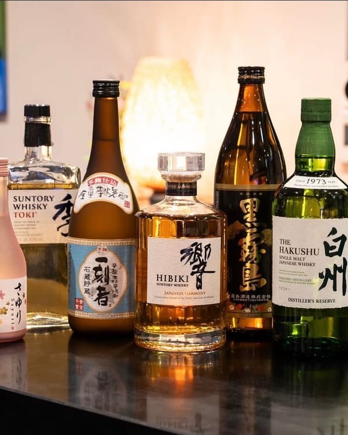 Bottles of Japanese sake, shochu, umeshu and whisky, including Hibiki and Hakushu, lined up on the bar at Momo